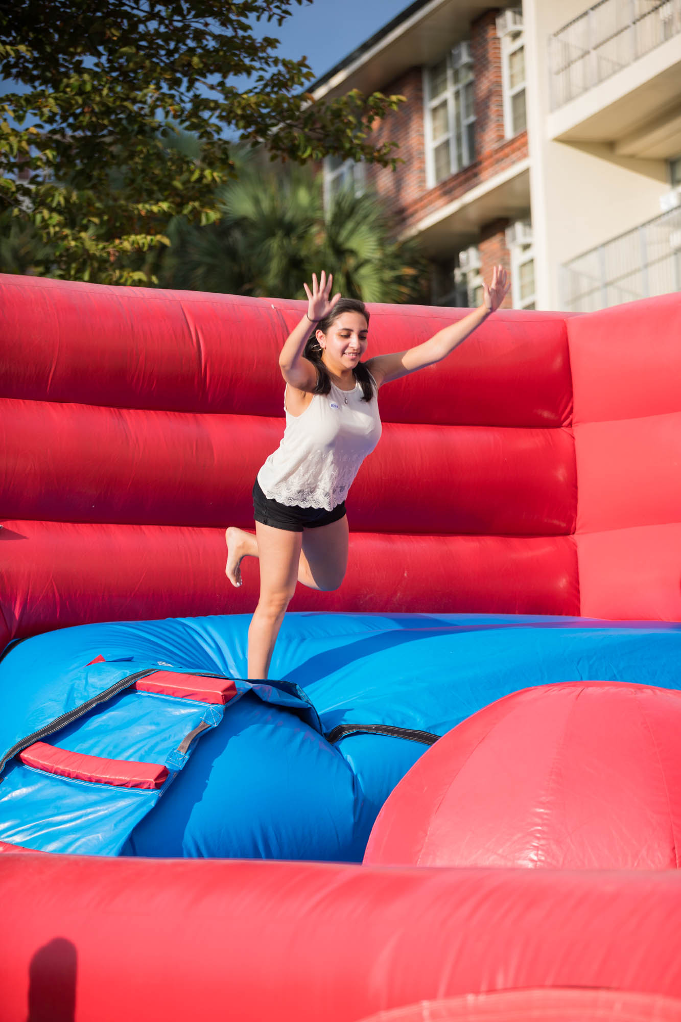 A student bounces around on a giant inflatable obstacle course.