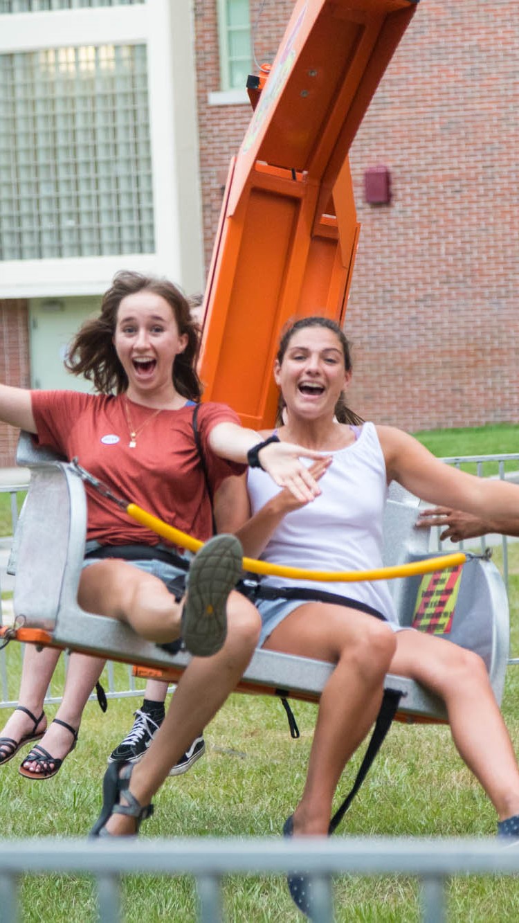 Two students ride a fair ride during an event.