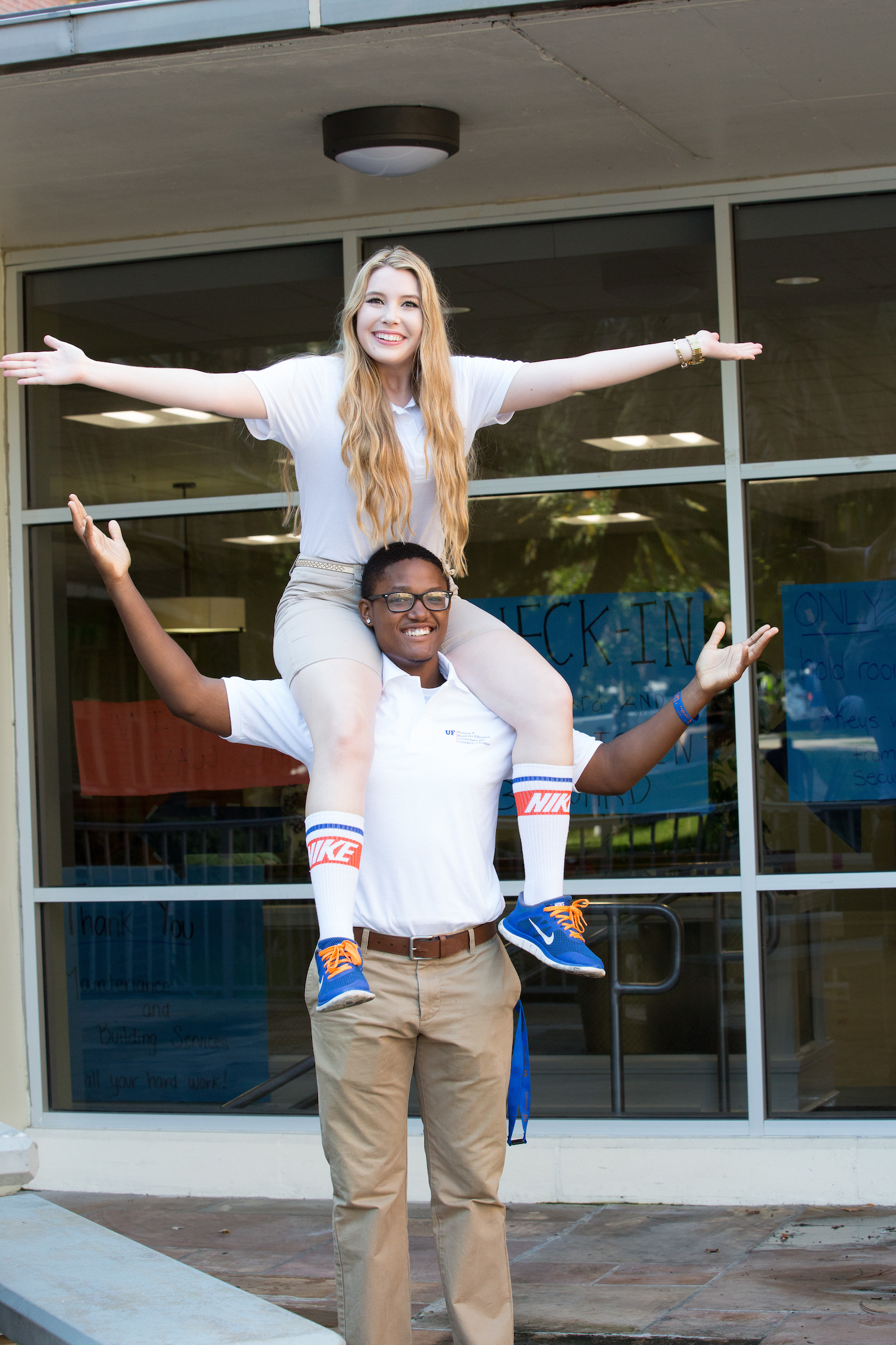 A student sits on the shoulders of another student during move-in.