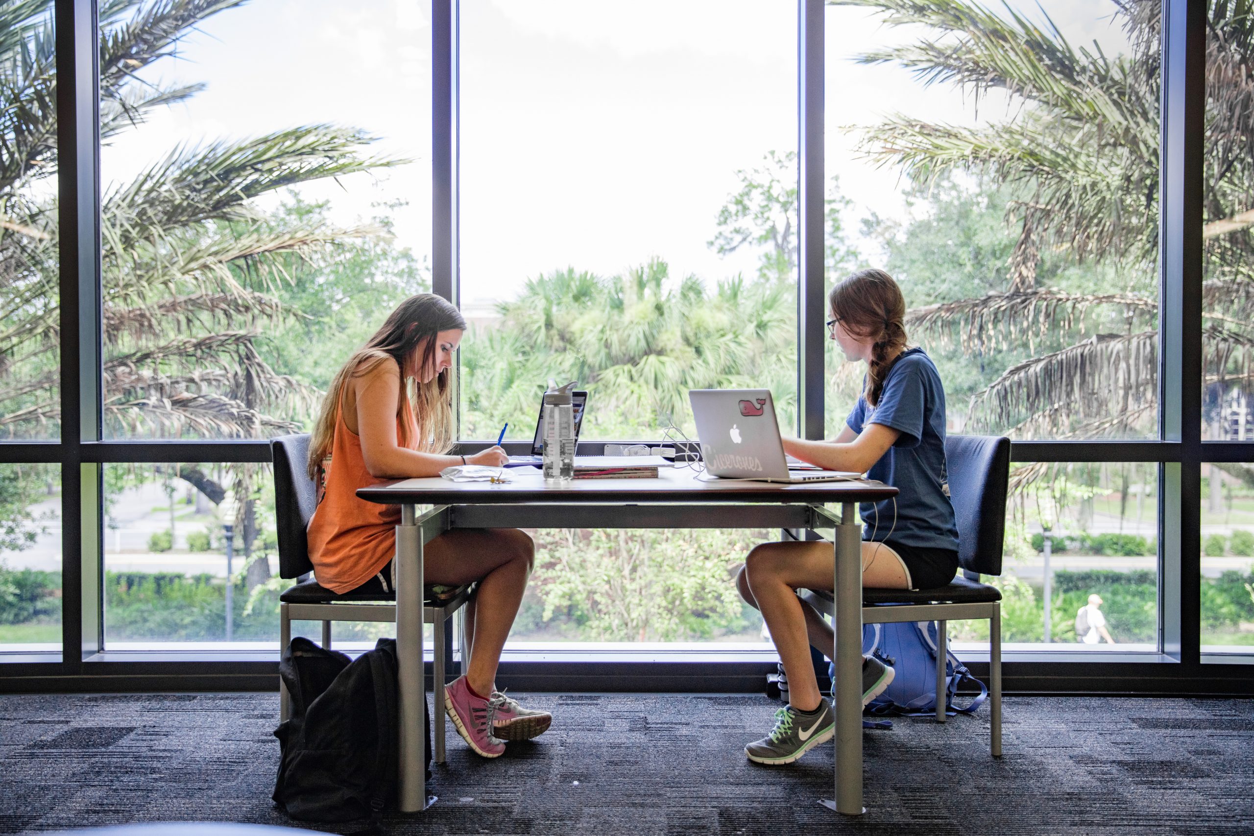 Two female students student in a library.