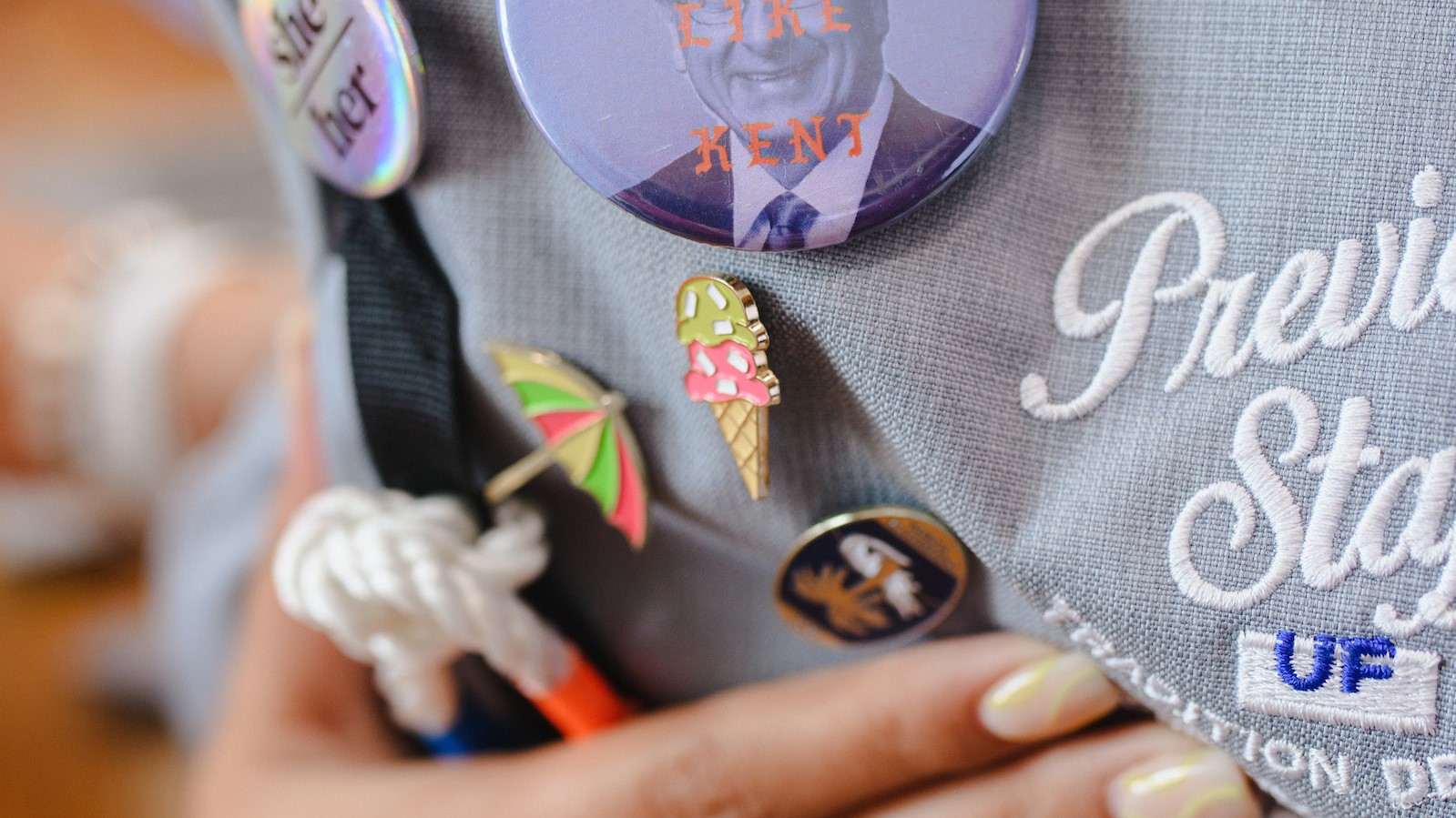 Pins and buttons on the back of a gray backpack.