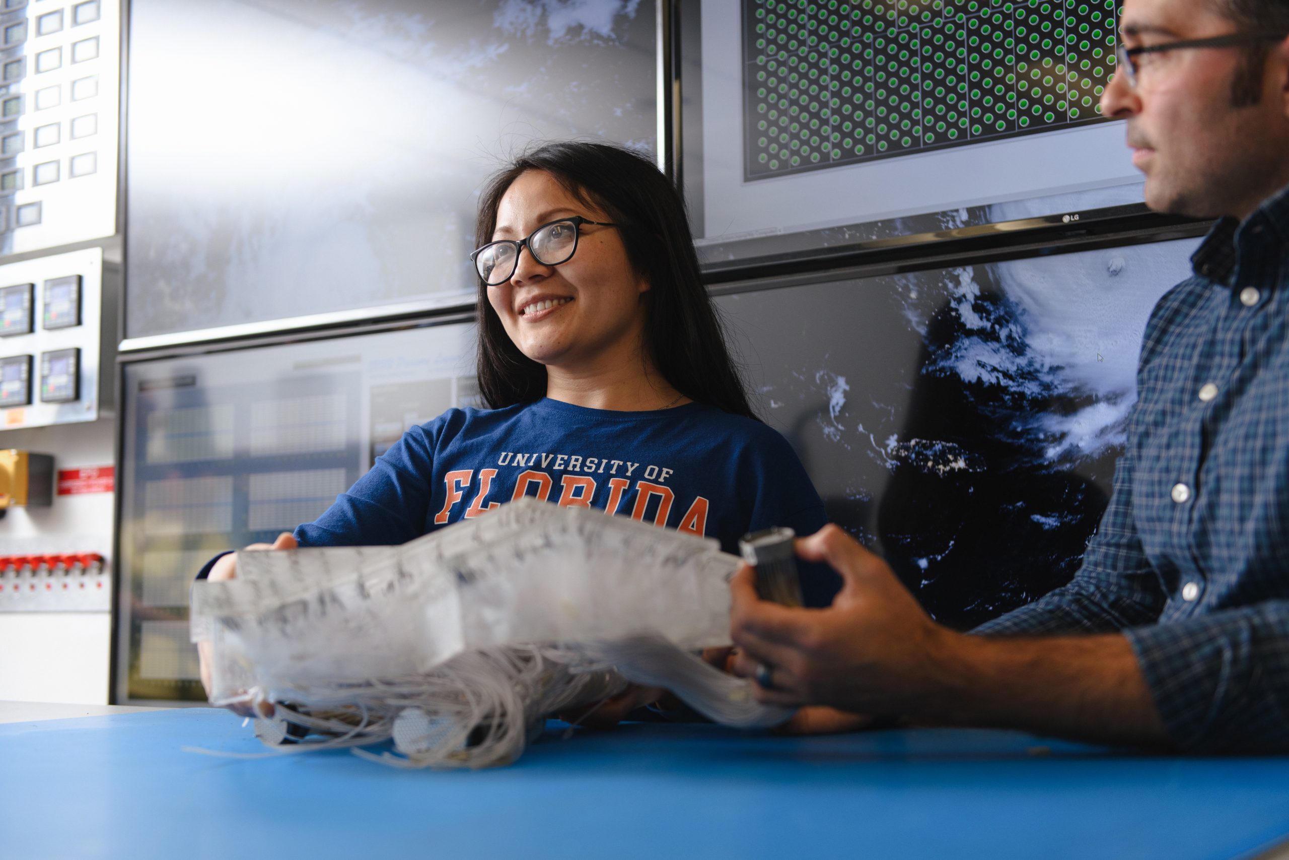 Two students talk at a table.