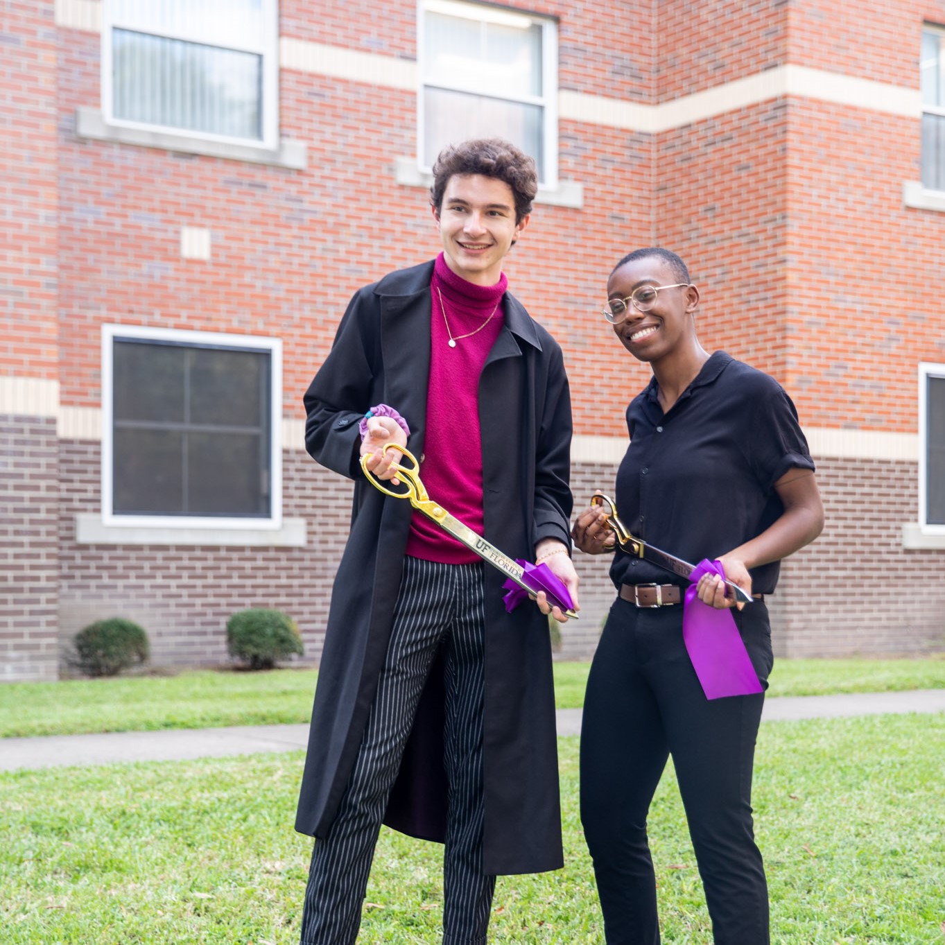 Two student hold purple ribbon from the Lavender LLC Ribbon Cutting.