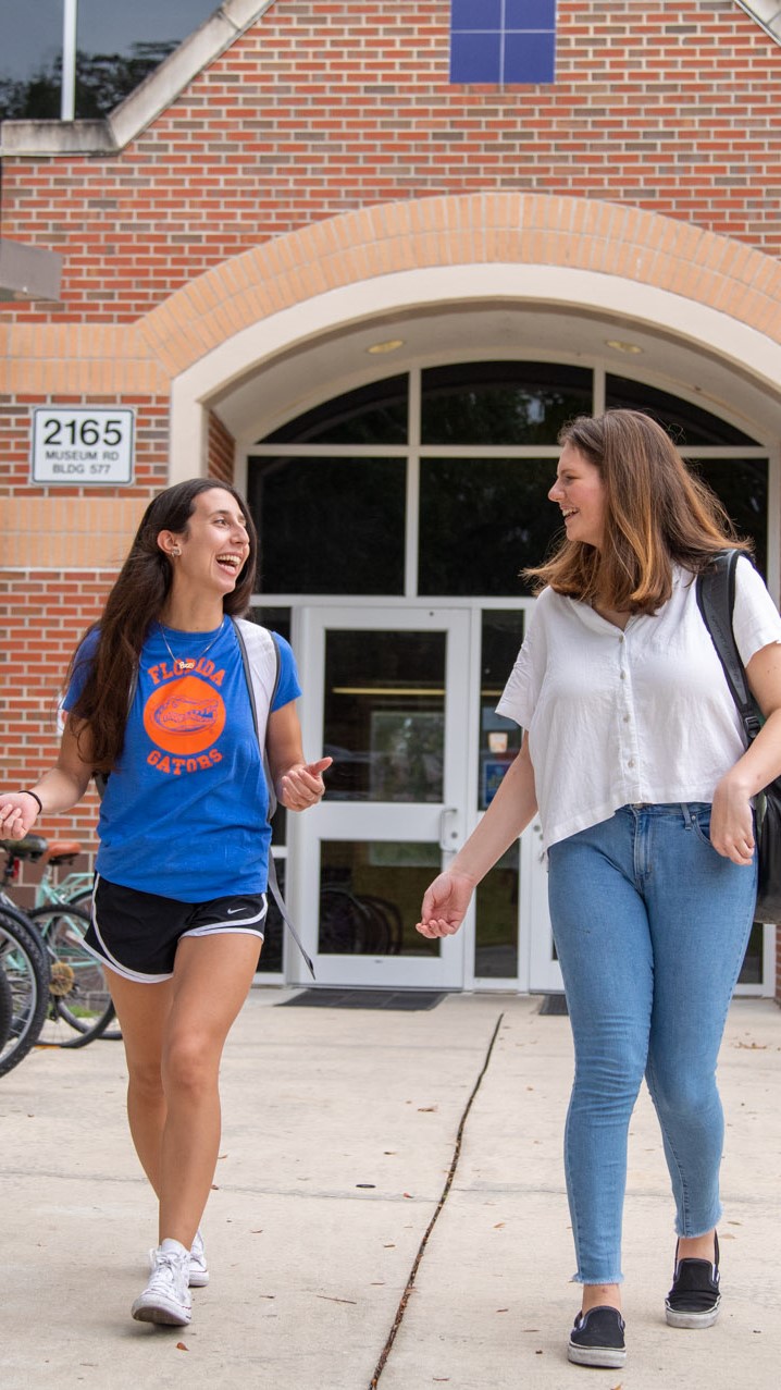 Two female students talk as they walk out of Hume Hall.