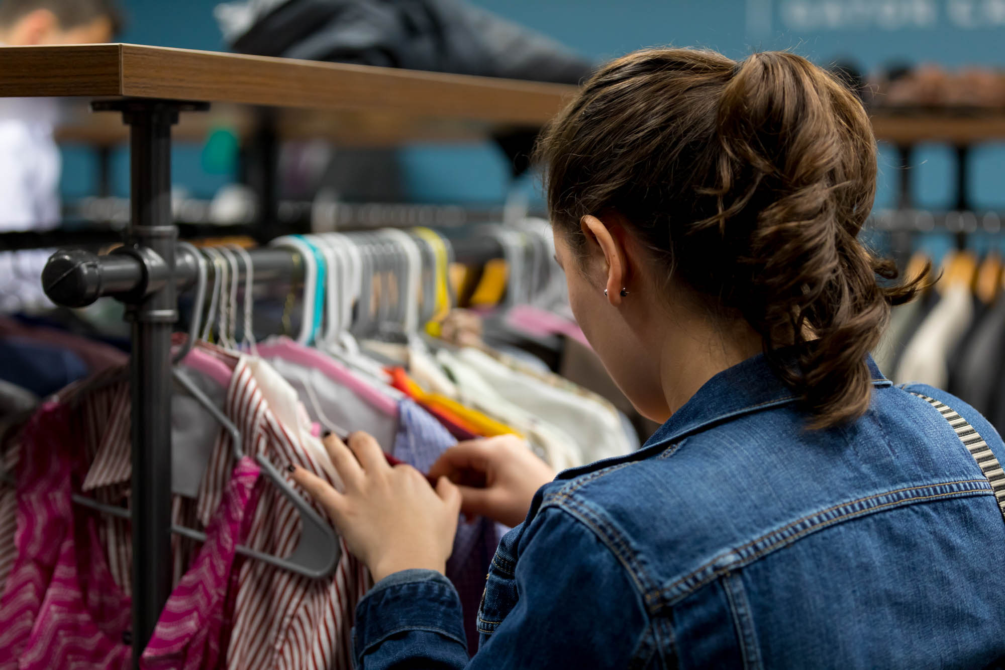 A student looks through a rack of clothes in search of a great outfit for their interview.