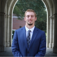 Professional headshot of Coe Leavengood in the Sledd archway.